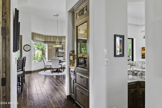 hall with dark hardwood / wood-style floors and a high ceiling