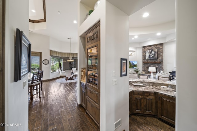 corridor with a towering ceiling and dark hardwood / wood-style flooring