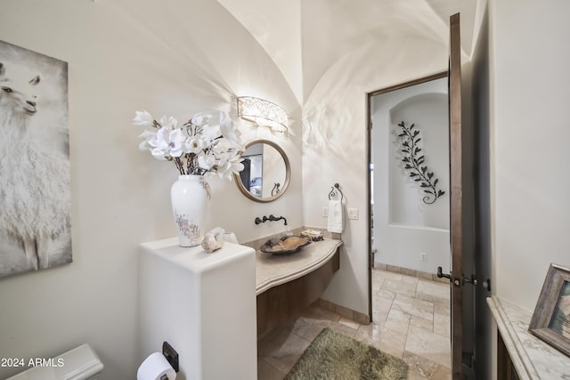 bathroom with vanity, lofted ceiling, and toilet