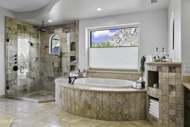 bathroom featuring vanity, plus walk in shower, and a wealth of natural light