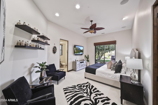 bedroom with light carpet, ensuite bath, and ceiling fan