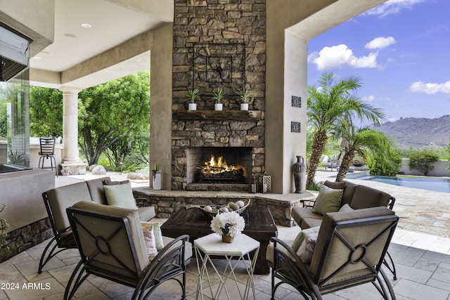 view of patio / terrace with a mountain view and an outdoor stone fireplace