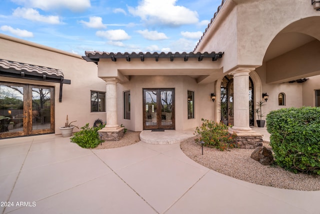 view of exterior entry featuring a patio area and french doors