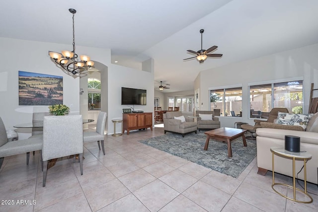 living room with light tile patterned flooring, vaulted ceiling, and ceiling fan with notable chandelier