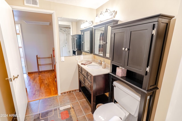 bathroom featuring vanity, hardwood / wood-style flooring, and toilet