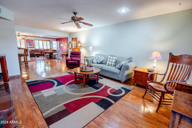 living room with wood-type flooring and ceiling fan