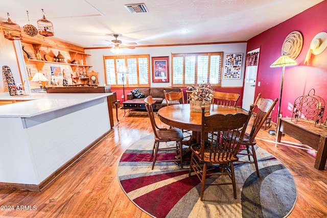 dining area with ceiling fan, crown molding, and light wood-type flooring