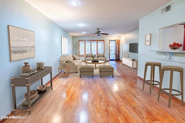 living room featuring ceiling fan and light hardwood / wood-style floors