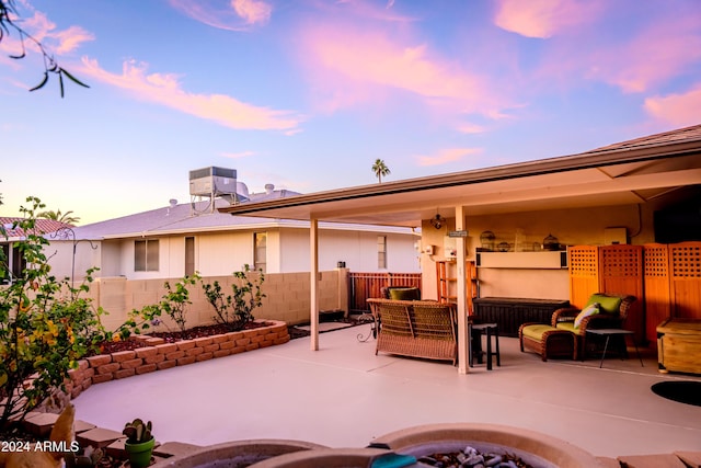 patio terrace at dusk with cooling unit and an outdoor hangout area