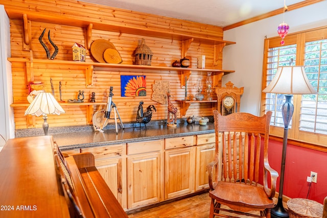 kitchen featuring light brown cabinetry, light wood-type flooring, and crown molding