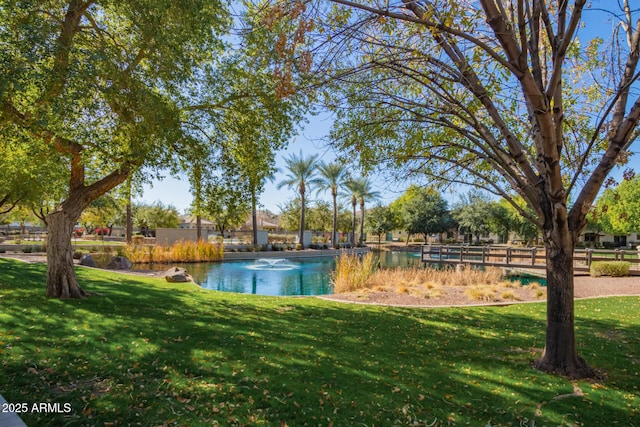 exterior space featuring a lawn and a water view