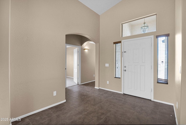 2620 E Rustling Oaks Ln, Phoenix, AZ 85024 - entryway with arched walkways, dark tile patterned floors, high vaulted ceiling, and baseboards