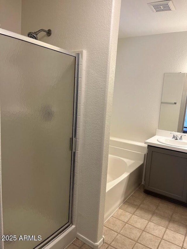 full bath featuring a shower stall, visible vents, a bath, and a textured wall