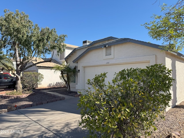 view of front of home featuring an attached garage, driveway, and stucco siding