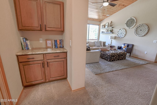 kitchen featuring wooden ceiling, light carpet, ceiling fan, and vaulted ceiling