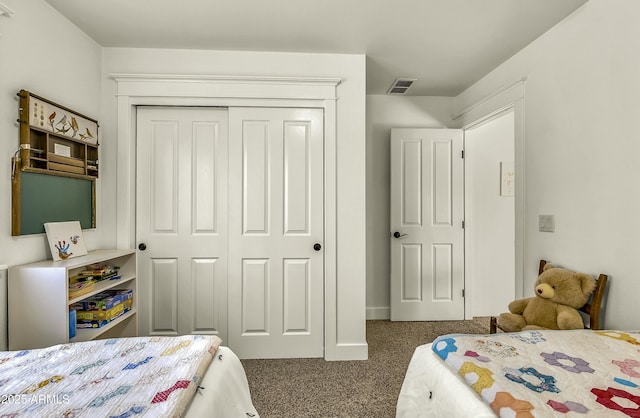 carpeted bedroom with visible vents, baseboards, and a closet