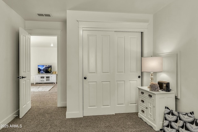 bedroom with visible vents, a closet, and dark colored carpet