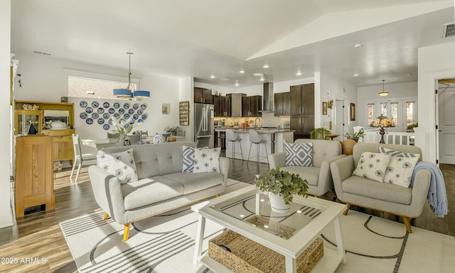 living area with visible vents, recessed lighting, wood finished floors, and vaulted ceiling