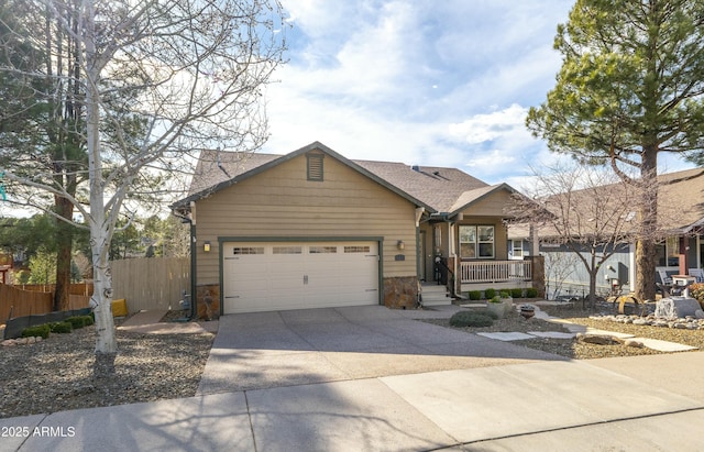 view of front of property featuring an attached garage, fence, driveway, and stone siding