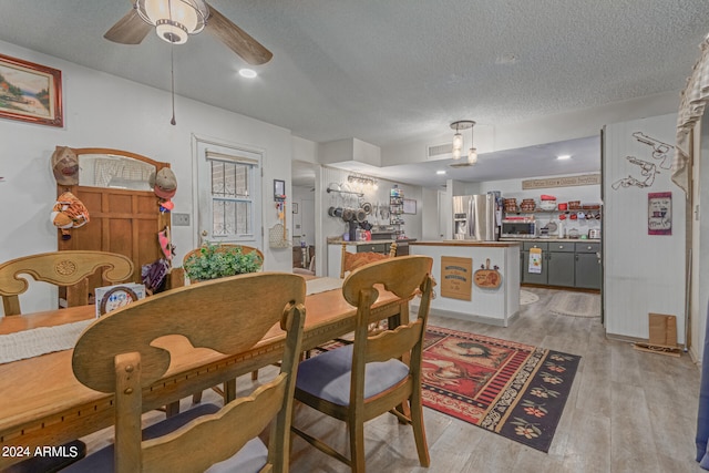 dining area featuring a textured ceiling, light hardwood / wood-style floors, and ceiling fan