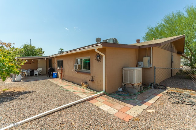 rear view of house featuring a patio area and central AC