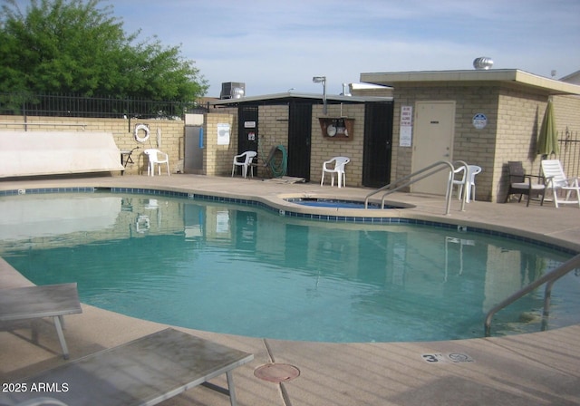 view of swimming pool featuring a patio area, a community hot tub, and central AC