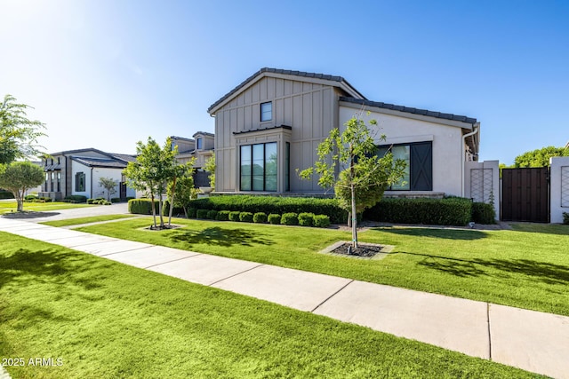 3684 E Boot Track Trl, Gilbert, AZ 85296 - modern inspired farmhouse with board and batten siding, a front yard, and a gate