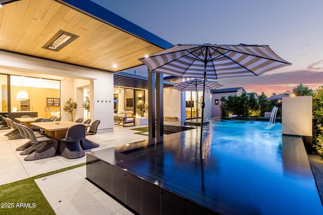3684 E Boot Track Trl, Gilbert, AZ 85296 - pool at dusk with a patio area, an outdoor pool, and outdoor dining space