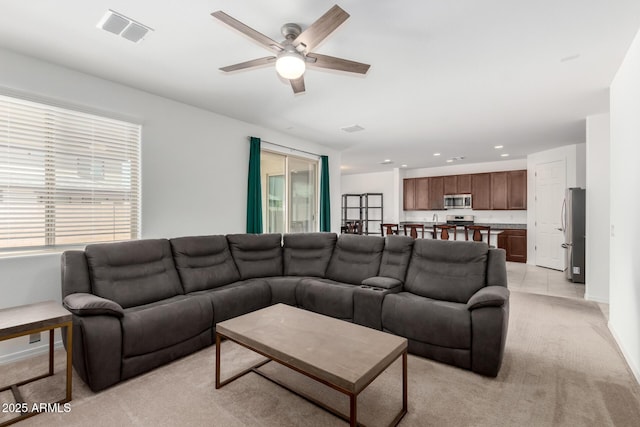 living area with a ceiling fan, light colored carpet, visible vents, and recessed lighting