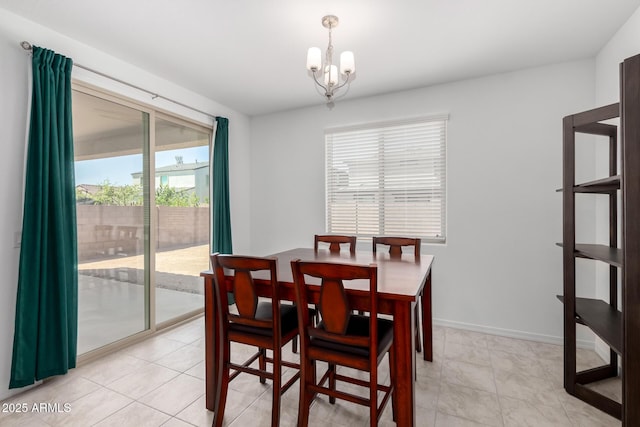 dining area with a healthy amount of sunlight, baseboards, and a notable chandelier