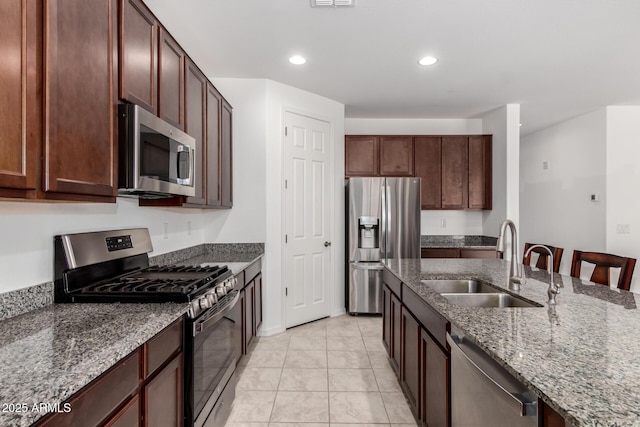 kitchen featuring recessed lighting, appliances with stainless steel finishes, stone counters, and a sink