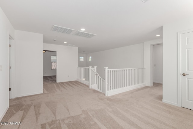 empty room featuring carpet floors, recessed lighting, baseboards, and visible vents