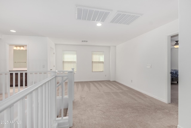empty room featuring baseboards, visible vents, recessed lighting, and light colored carpet