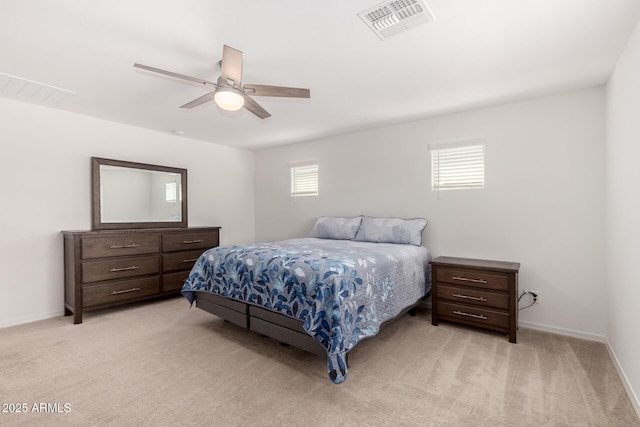 bedroom with baseboards, visible vents, light carpet, and ceiling fan