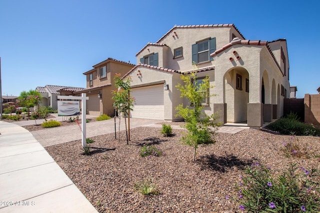 mediterranean / spanish-style home with a garage, fence, stucco siding, driveway, and a tile roof