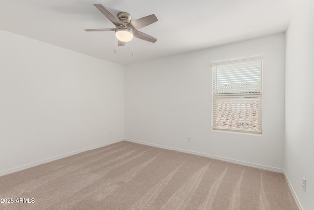 empty room featuring baseboards, light carpet, and ceiling fan