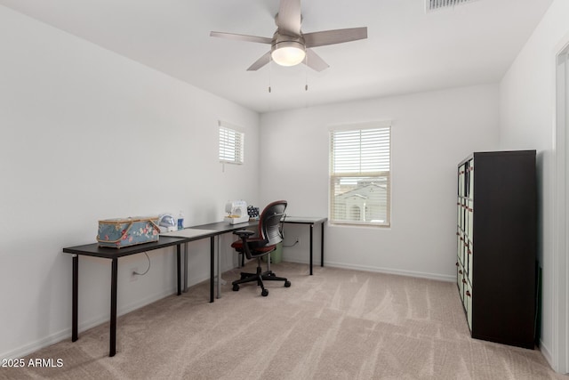 carpeted home office with baseboards, a ceiling fan, and visible vents