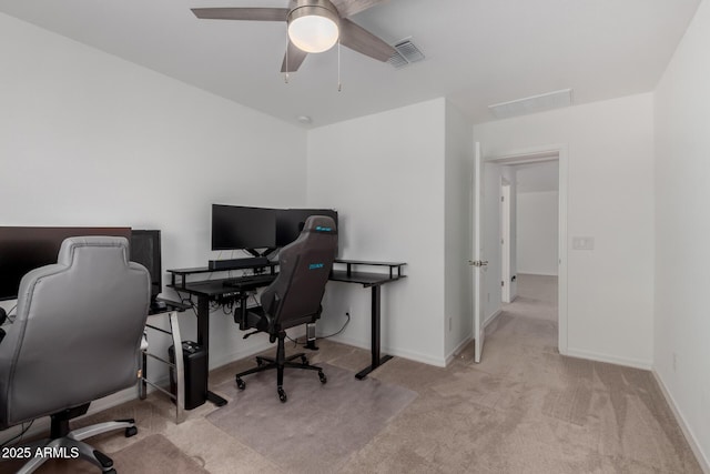 carpeted office space with baseboards, ceiling fan, and visible vents