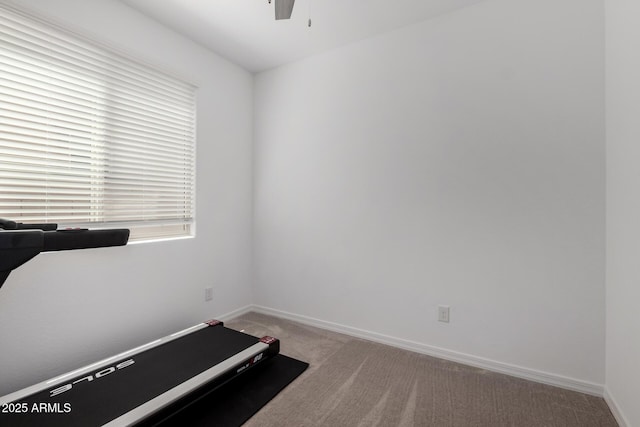 workout area with ceiling fan, light carpet, and baseboards
