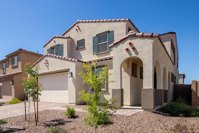 mediterranean / spanish-style house with an attached garage, stucco siding, a tiled roof, and driveway