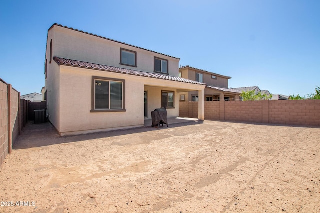 rear view of property featuring stucco siding, a fenced backyard, a patio area, central air condition unit, and a tiled roof