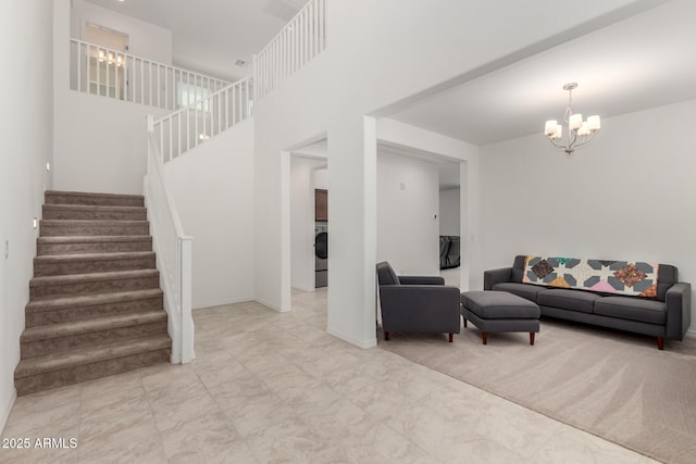 living area with washer / clothes dryer, a notable chandelier, and stairway