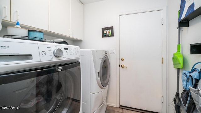 washroom featuring washer and dryer, cabinets, and light tile patterned flooring