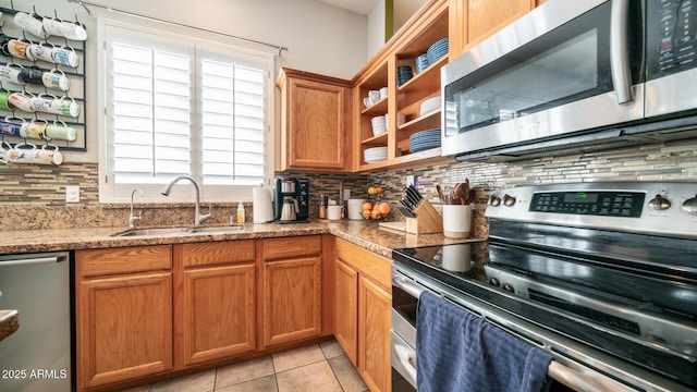 kitchen with tasteful backsplash, appliances with stainless steel finishes, sink, and light tile patterned floors