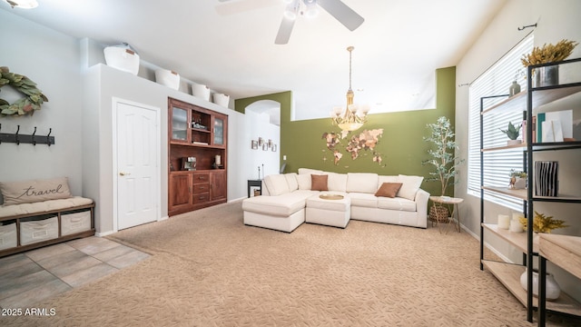 carpeted living room with ceiling fan with notable chandelier