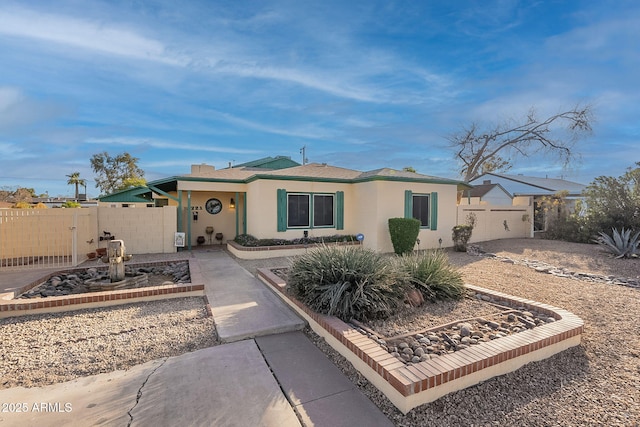 single story home featuring fence, a gate, and stucco siding