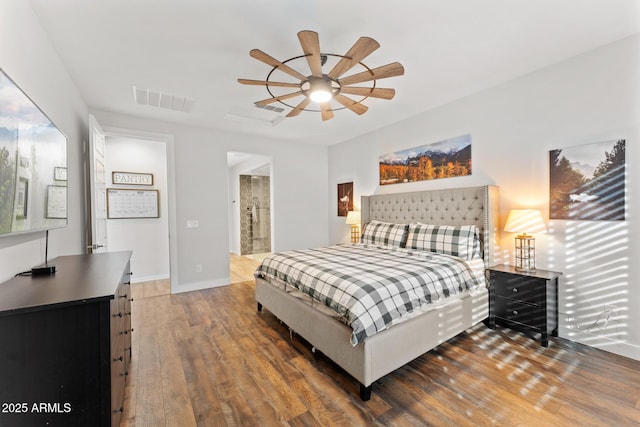 bedroom featuring dark wood-type flooring, ceiling fan, and ensuite bath