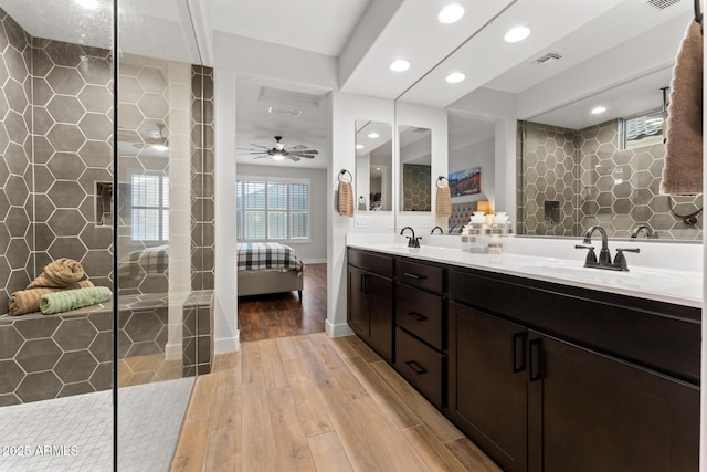 bathroom featuring vanity, hardwood / wood-style flooring, ceiling fan, and a tile shower