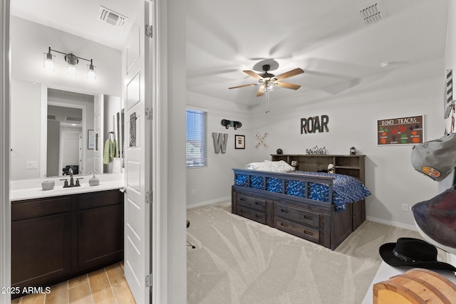 bedroom featuring sink, connected bathroom, and ceiling fan