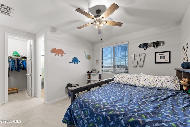 bedroom with a walk in closet, a closet, and ceiling fan